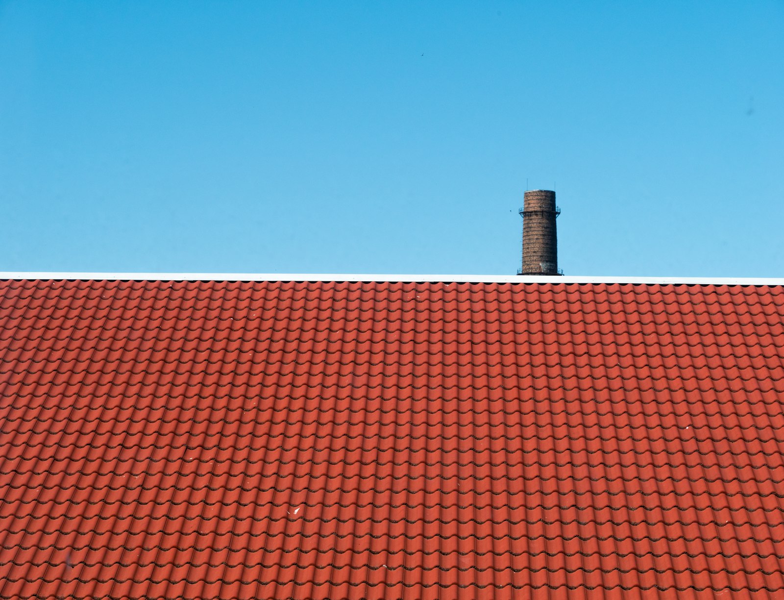 Toiture en tuiles terre cuite sous ciel bleu — TLS Toiture Toulouse